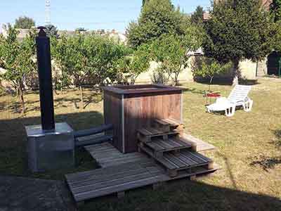 Wood-fired hot tub in the private garden of a studio apartment in Subotica